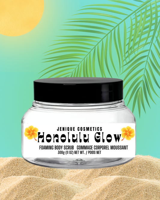 Jar of Jenique Cosmetics Honolulu Glow Foaming Body Scrub with a tropical leaf and sand background